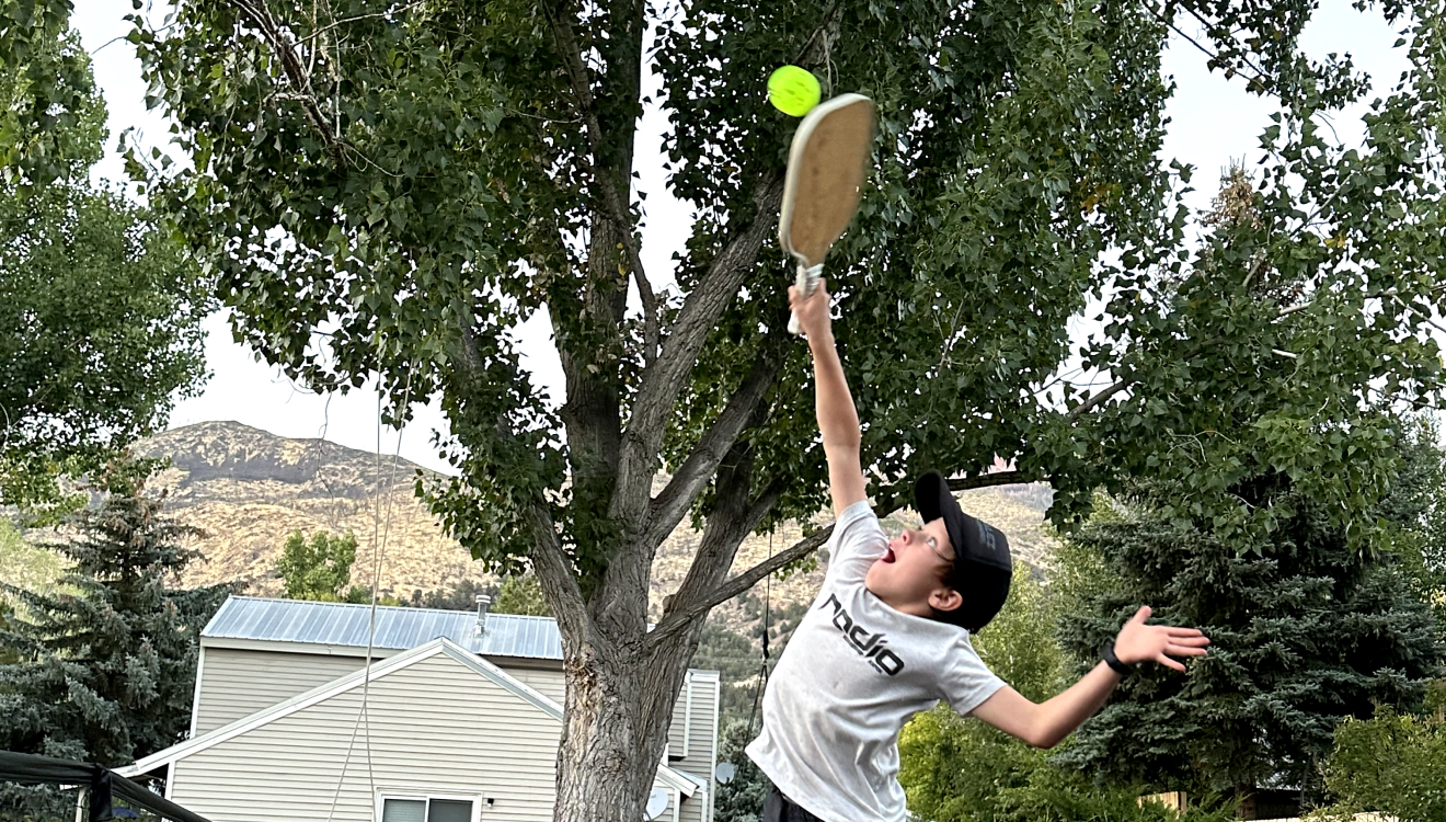 Kids playing pickleball on the court